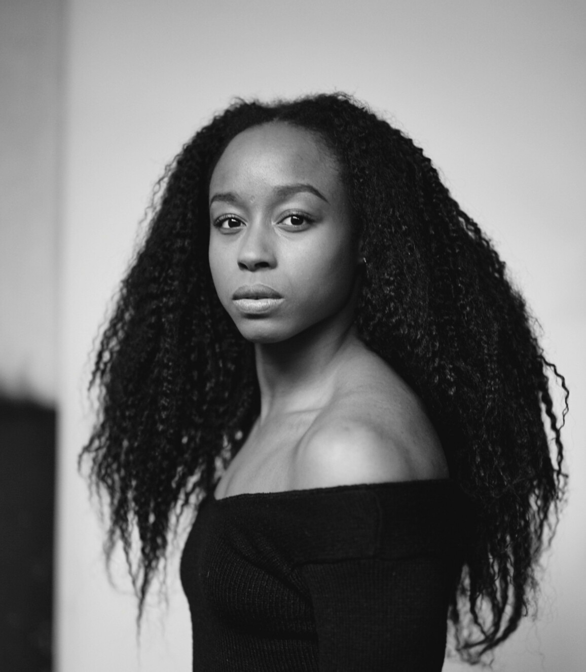 Black and white image of a woman with a black strapless top and long hair.