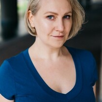 A blond woman wearing a blue t-shirt