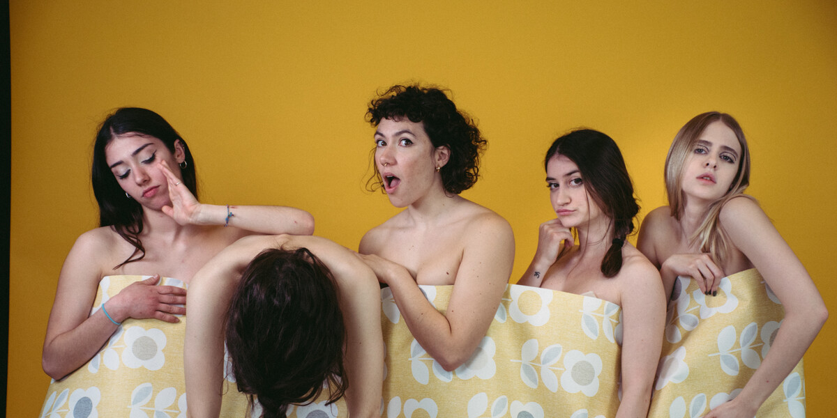 Image of five dancers standing in a line with a piece of wallpaper connecting them