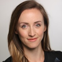 Image of Stephanie De'Ath. Steph has light brown hair and smiles at the camera. She is wearing a dark top.