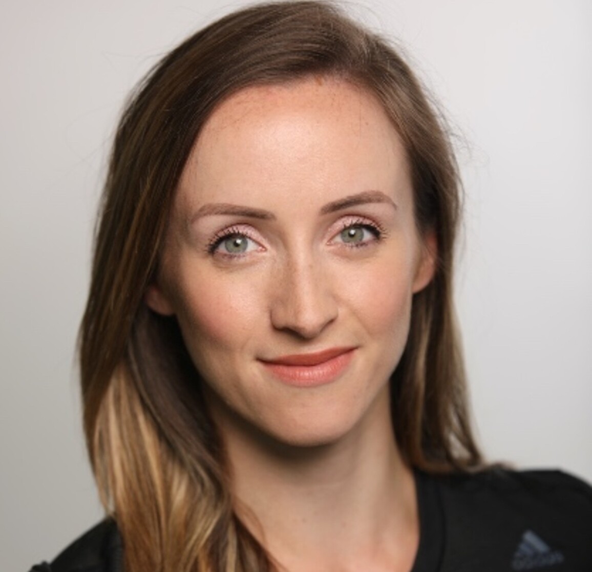 Image of Stephanie De'Ath. Steph has light brown hair and smiles at the camera. She is wearing a dark top.