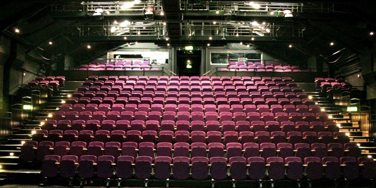 a photo of The Place theatre seats taken from the stage. The seats are purple and empty.